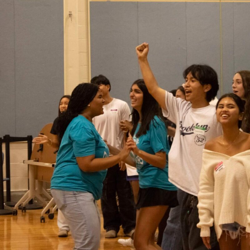 Stanton College Prep Students raise hands with smiles on faces to participate in their mentoring session.