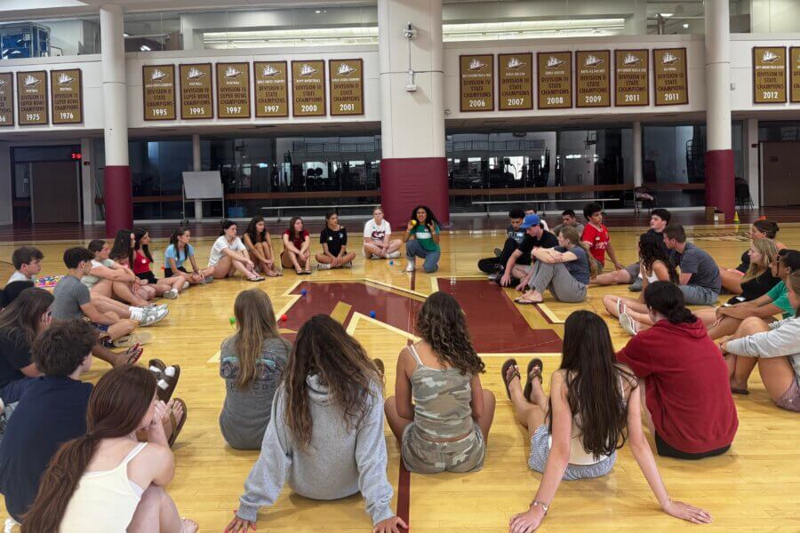 Newburyport and Georgetown High School mentors gather in a circle to debrief the activity.