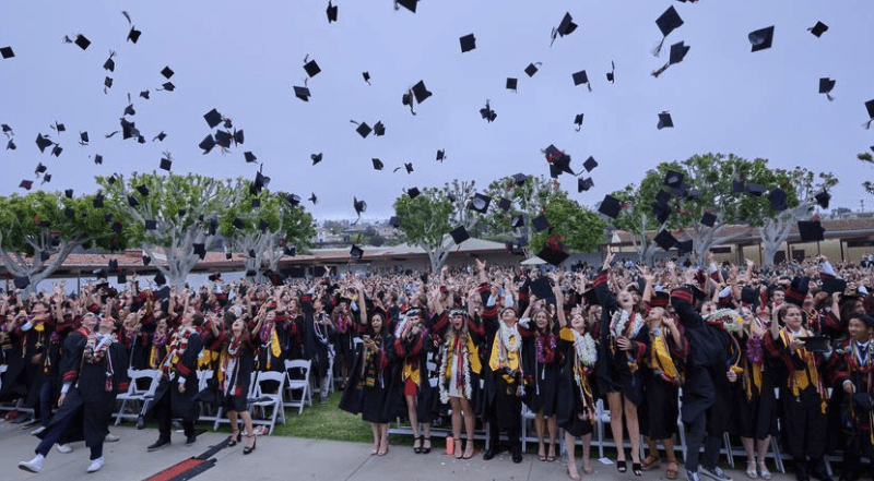 Graduating students toss caps in celebration